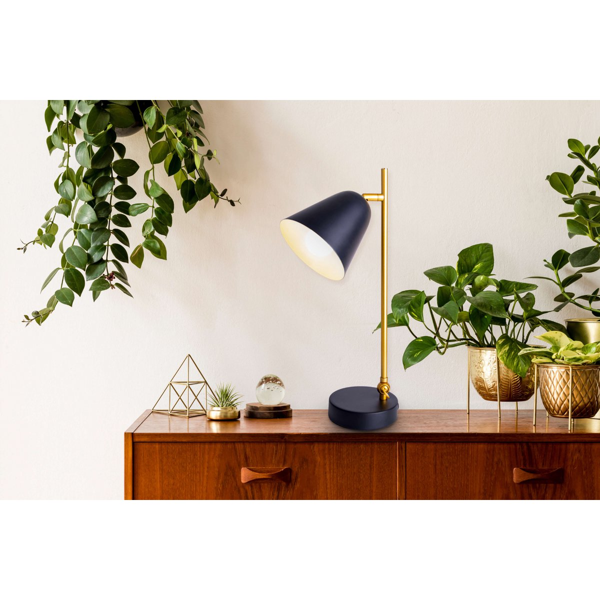 De "Triton" tafellamp gemaakt van zwart en messing gekleurd metaal is 42,5 cm hoog, heeft een E14-versie en is ideaal voor woonkamer, gang, kantoor of dessert